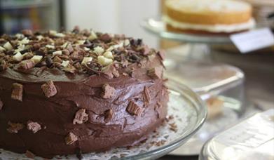 A chocolate cake on a cafe counter.