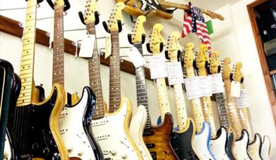 Guitars on display on the wall of Old Hat Guitars shop in Horncastle